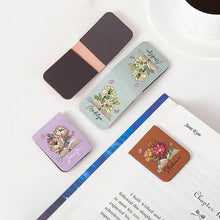 Four colorful custom magnetic leather bookmark with floral designs on a book