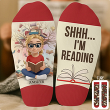 Woman relaxing on a cozy sofa wearing her custom book lover crew socks.