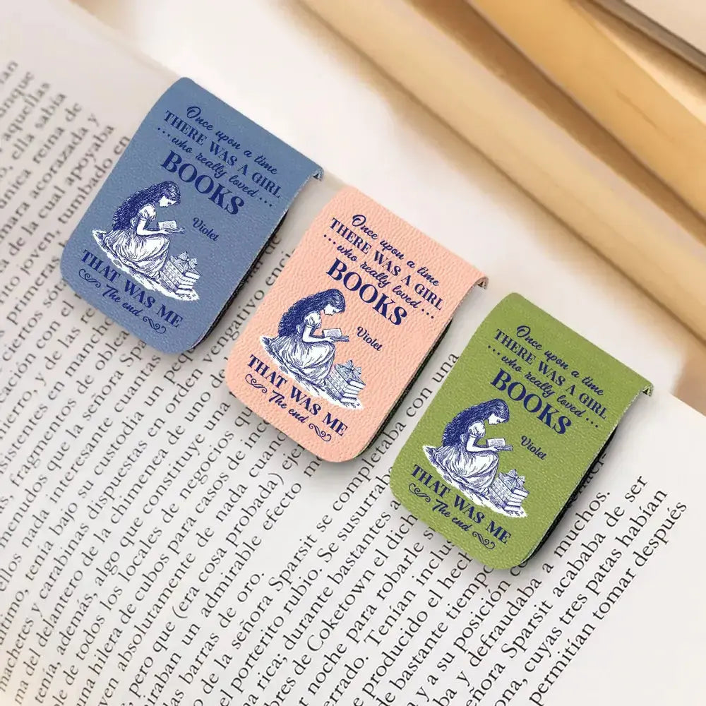 Three personalized custom leather bookmarks with illustrations and text on a book page.
