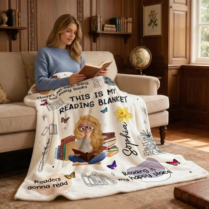 A woman sitting in a sunlit nook using a personalized book blanket with birth flowers.