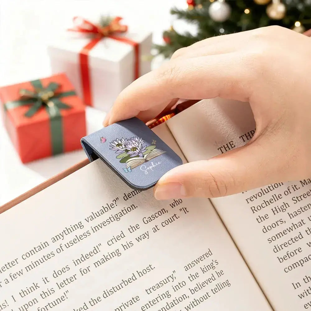 A beautiful custom PU leather bookmark with name holding thick book pages.