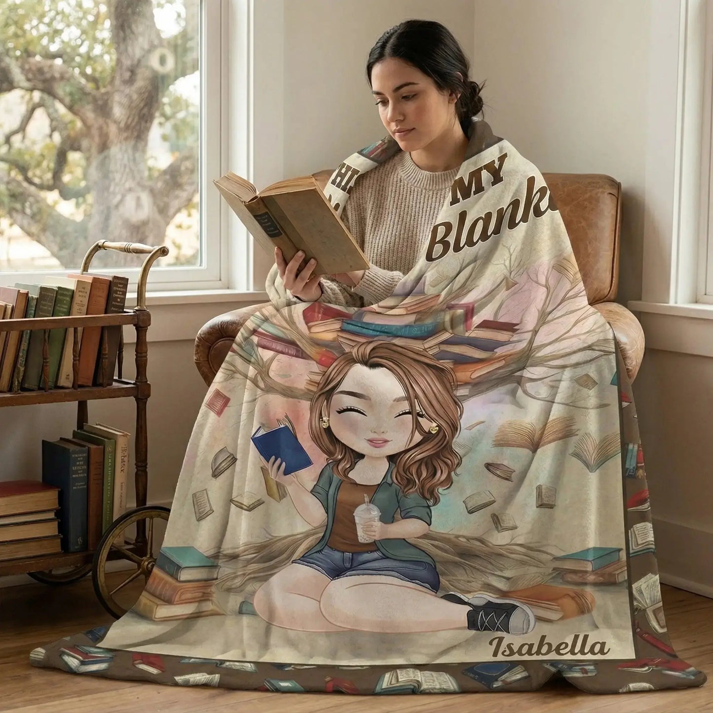 Woman wrapped in a personalized reading blanket holding a hardcover book