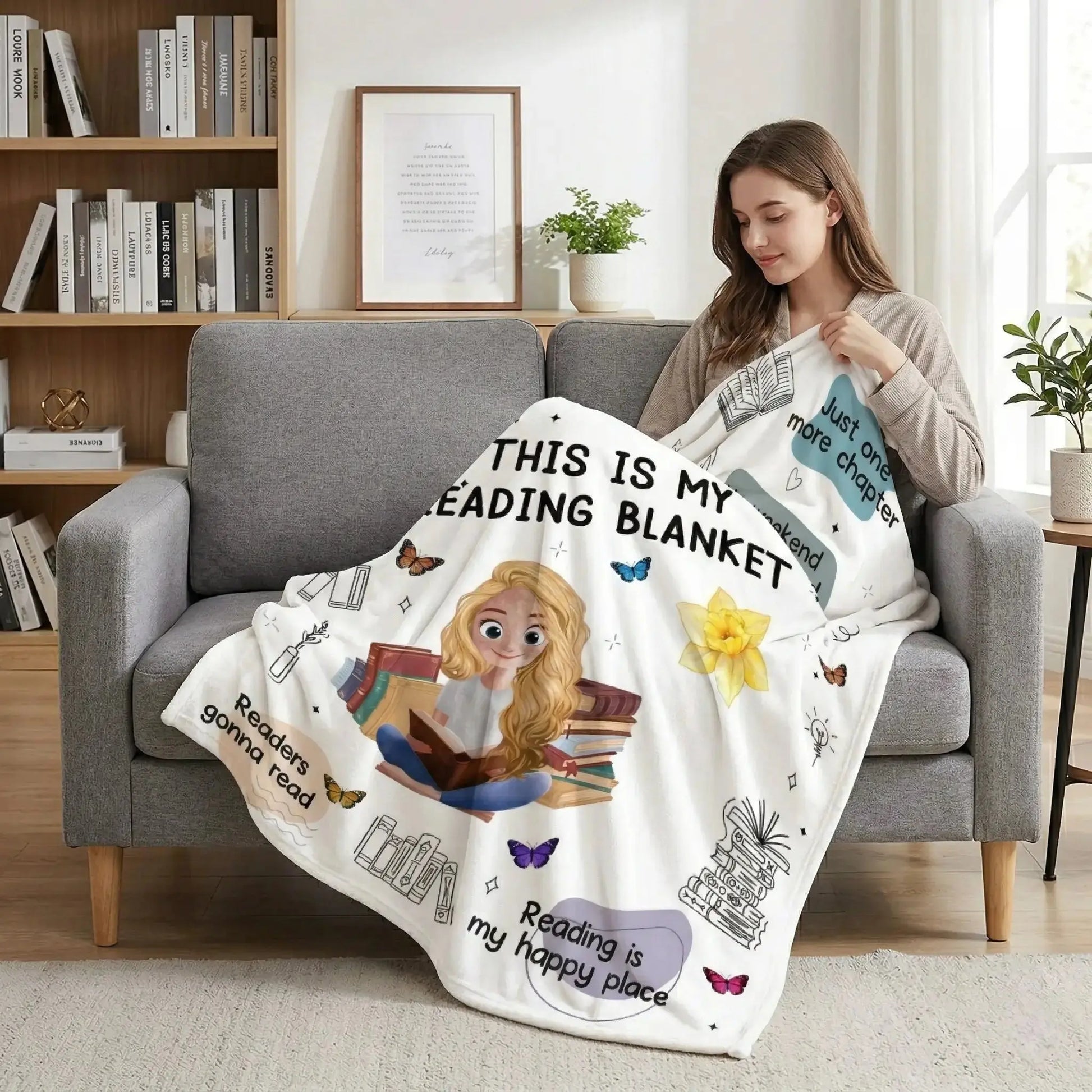 A woman sitting in a sunlit nook using a personalized book blanket with birth flowers.