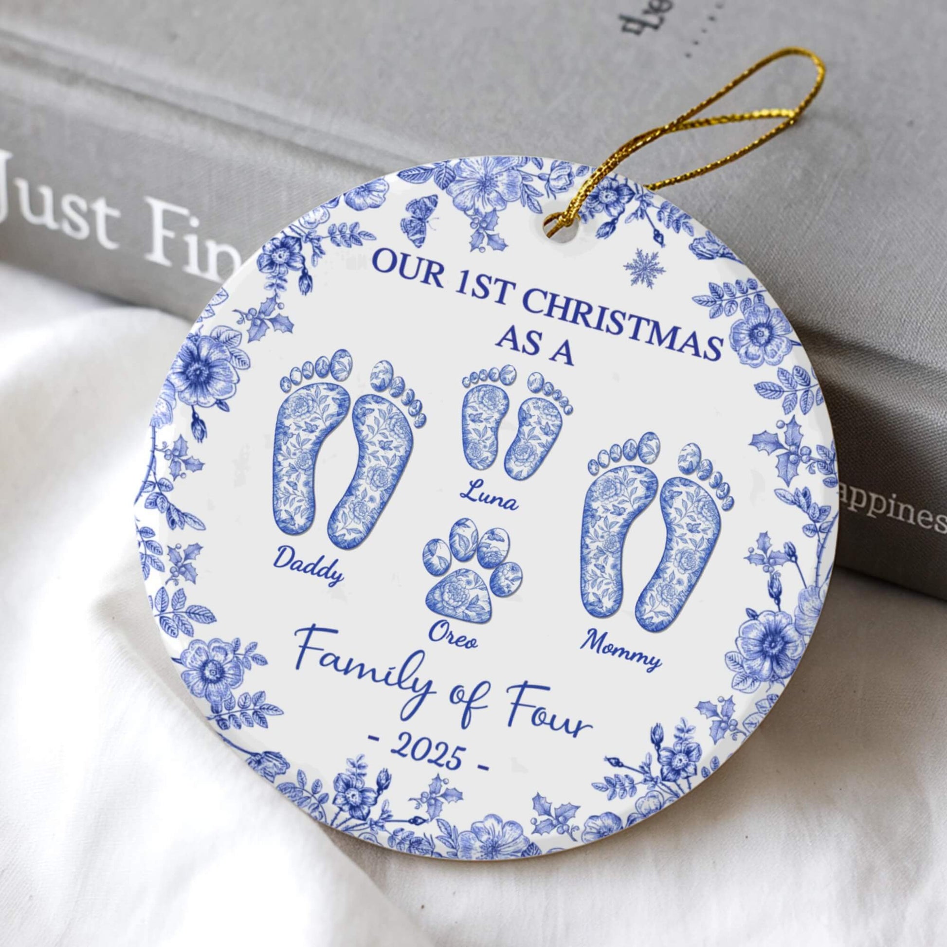 Personalized round ceramic ornament with blue floral border, family footprints and names, 2025.