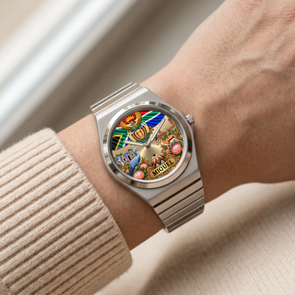 Silver-tone South African flag watch with custom name worn beside a cream sweater sleeve
