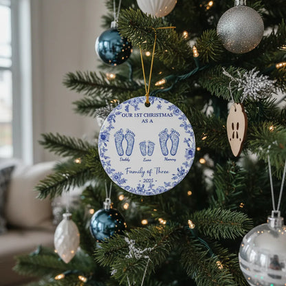 Custom round ceramic ornament with blue floral border and footprints for a family of three, 2025, on a Christmas tree.