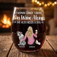 Personalized wine glasses with a design of a woman, dog, and text about wine and dogs, placed on a wooden surface with a warm background.